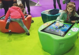 Enfants qui utilisent des tables multimédias interactives