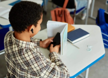 Élève distrait par une tablette en classe