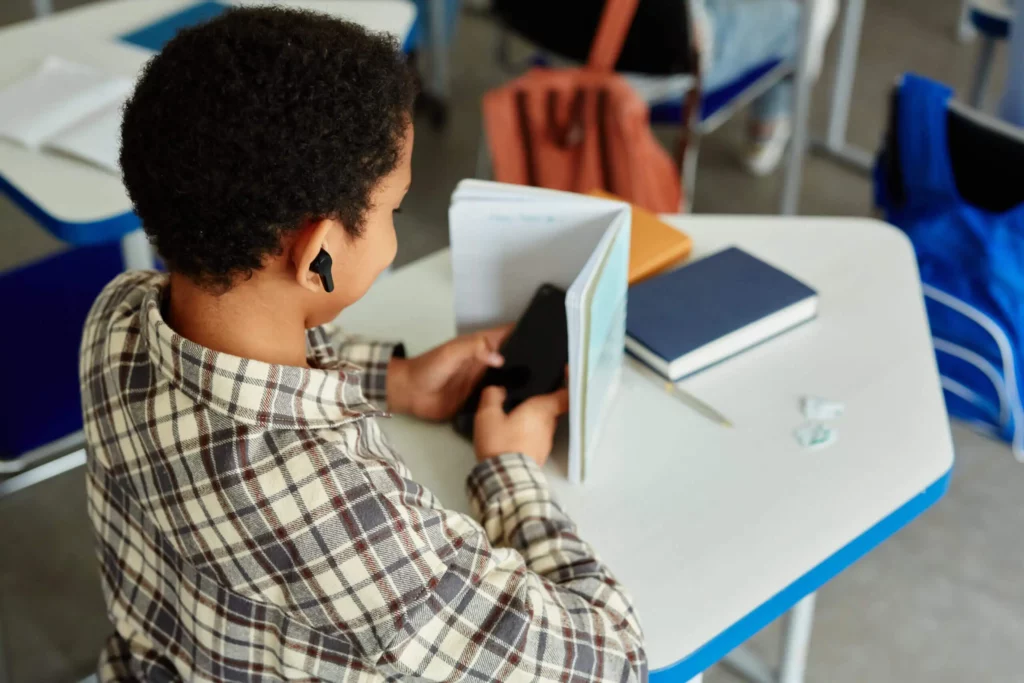 Élève distrait par une tablette en classe