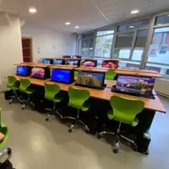 Salle informatique flexible équipée de tables multimédias escamotables pour une modularité totale.