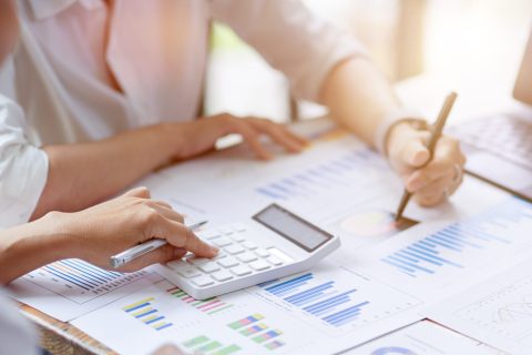 Close-up Businesswomen working together, calculates and estimates business investment turnover on financial data report chart and graph